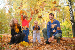 Family playing in fall leaves